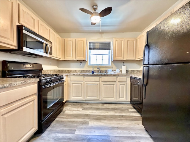 kitchen with light wood-type flooring, light countertops, a sink, and black appliances