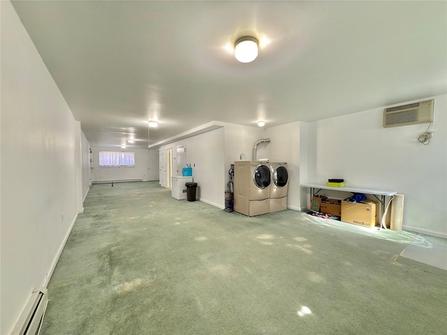 garage with a baseboard radiator, washing machine and dryer, a wall unit AC, and baseboards