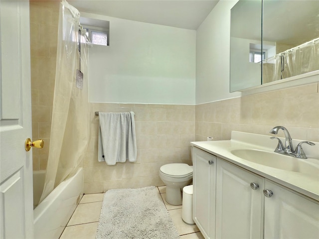 bathroom with tile patterned flooring, toilet, vanity, tile walls, and shower / tub combo with curtain