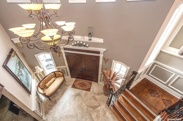 foyer entrance featuring stairs and a notable chandelier