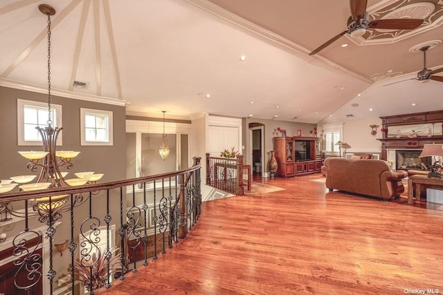 hall featuring ornamental molding, a healthy amount of sunlight, an upstairs landing, and wood finished floors