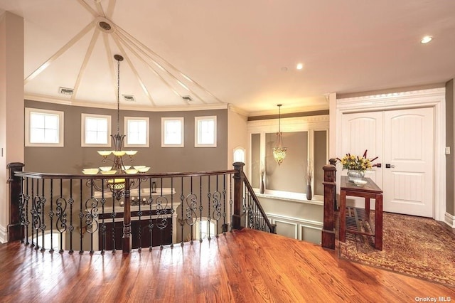 interior space featuring visible vents, crown molding, an upstairs landing, and an inviting chandelier