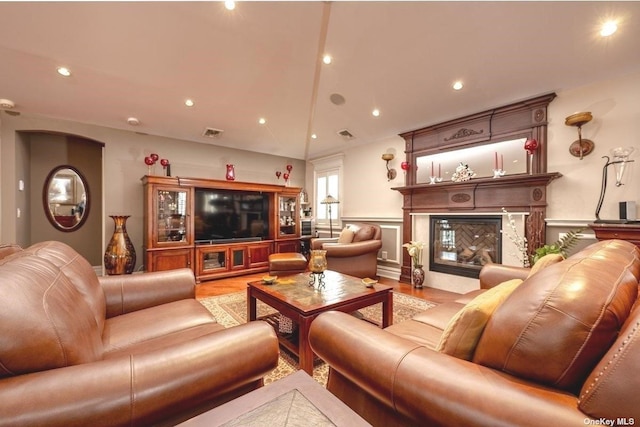 living room featuring recessed lighting, visible vents, wood finished floors, and a high end fireplace