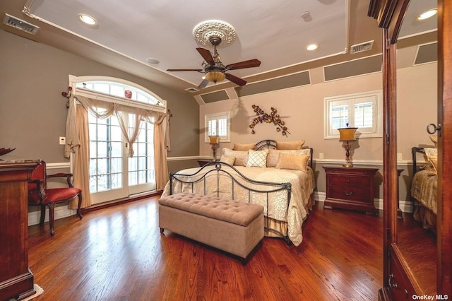 bedroom featuring lofted ceiling, visible vents, baseboards, and wood finished floors