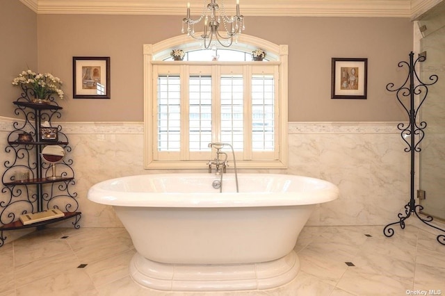 bathroom featuring wainscoting, crown molding, a freestanding bath, and an inviting chandelier