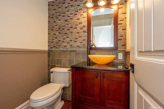 half bath featuring tasteful backsplash, tile walls, vanity, and toilet