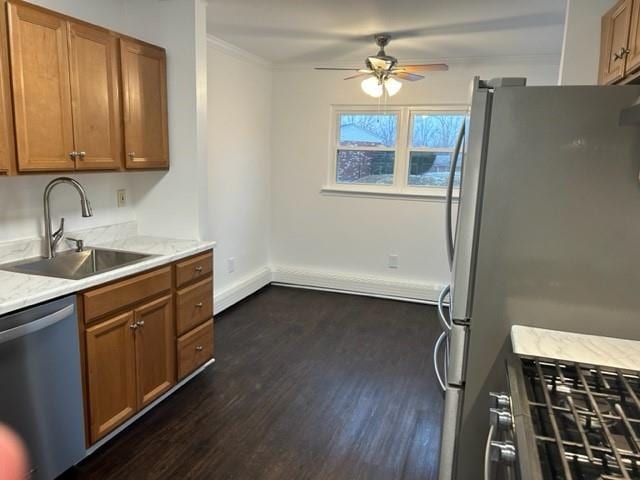 kitchen with crown molding, appliances with stainless steel finishes, brown cabinetry, and a sink