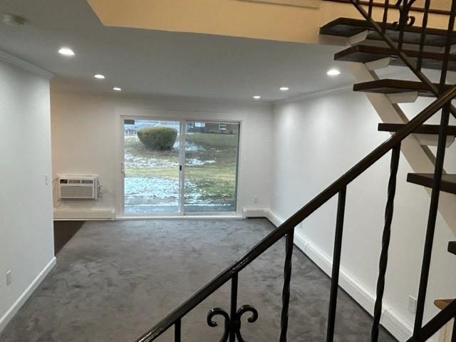 interior space with recessed lighting, baseboards, and a wall mounted air conditioner