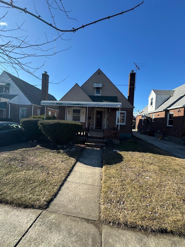 bungalow with a chimney and brick siding