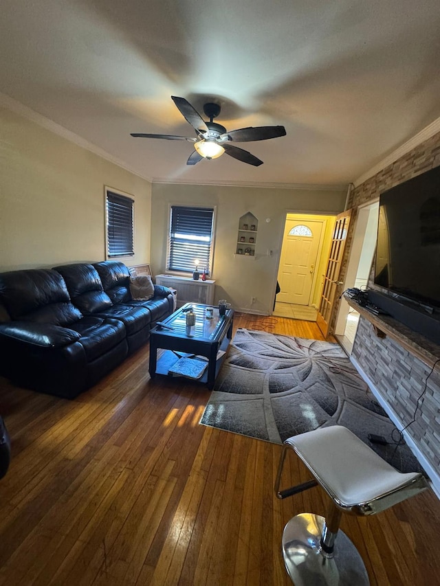 living room with wood-type flooring, crown molding, and ceiling fan