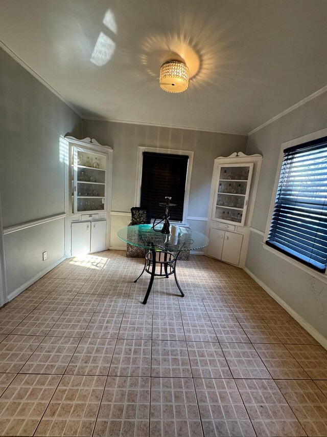 interior space with baseboards and crown molding