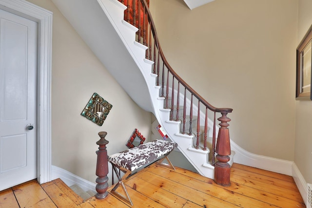 stairs featuring visible vents, baseboards, and hardwood / wood-style floors