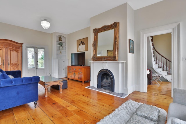 20 Stevenson St, Piermont, NY 10968 - living room with light wood-style flooring, stairway, and a fireplace with raised hearth