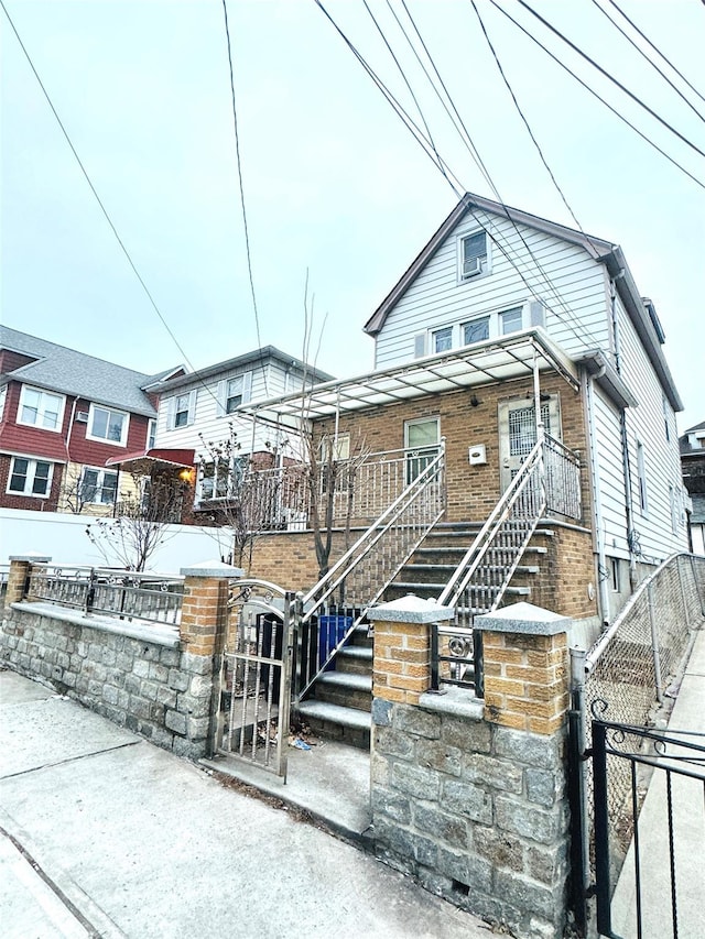 view of front of house featuring a fenced front yard, a gate, and brick siding