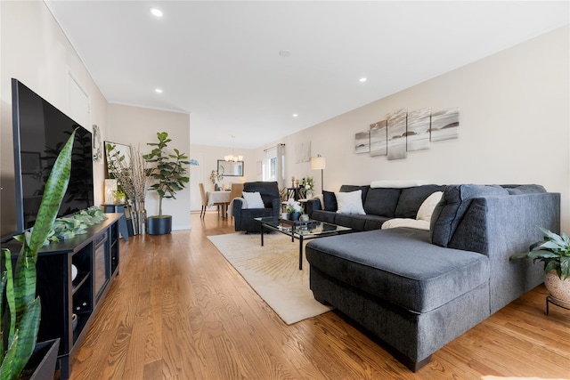 living area with light wood-style floors, recessed lighting, and a chandelier