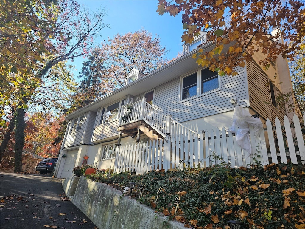 exterior space with a garage, driveway, and stairs