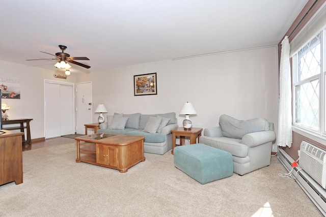 living room featuring ceiling fan, a baseboard radiator, baseboards, and a healthy amount of sunlight