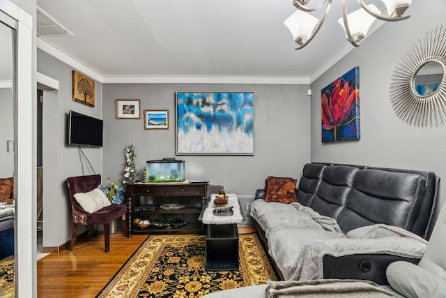 living area with ornamental molding, visible vents, and wood finished floors