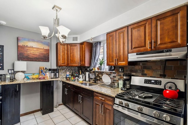kitchen featuring light stone counters, under cabinet range hood, a sink, visible vents, and stainless steel gas range