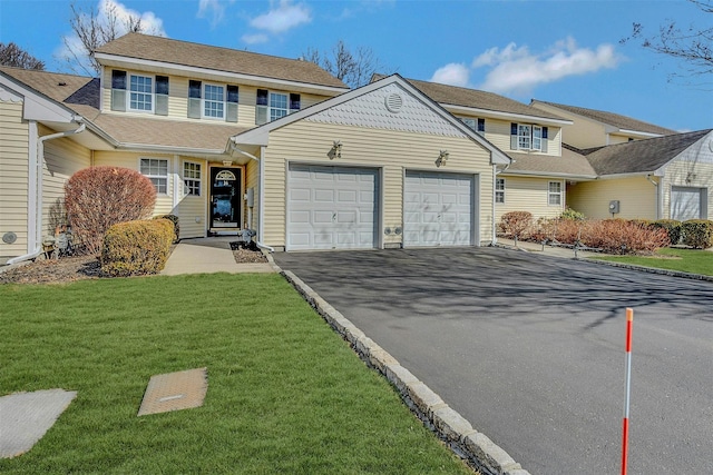 view of front of home with a garage, driveway, and a front lawn