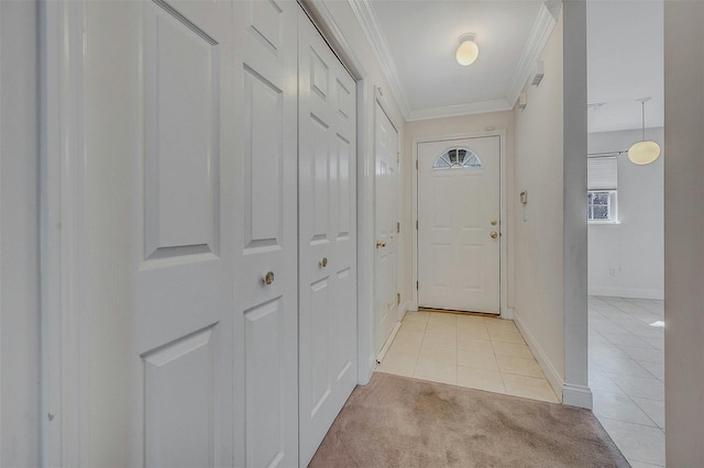 entryway with light carpet, baseboards, ornamental molding, and light tile patterned flooring