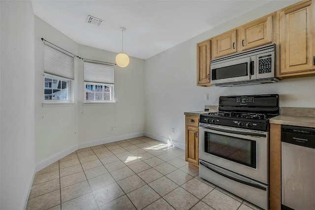 kitchen featuring stainless steel appliances, light tile patterned flooring, visible vents, and baseboards