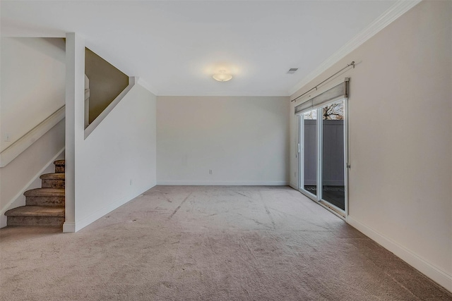 carpeted spare room with stairs, ornamental molding, visible vents, and baseboards