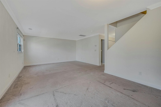 carpeted spare room with ornamental molding, visible vents, and baseboards