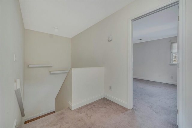 interior space featuring light colored carpet and baseboards