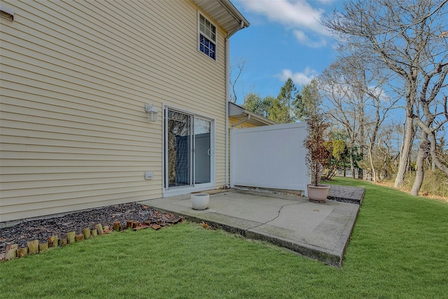 view of side of property with a yard, a patio area, and fence