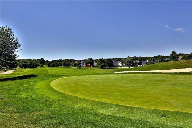 view of property's community featuring view of golf course and a yard