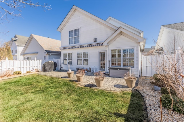 back of property featuring a fenced backyard, a patio, and a lawn