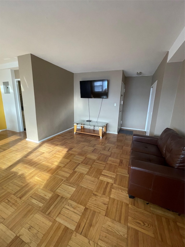 unfurnished living room with baseboards