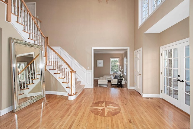 foyer with stairs, french doors, and wood finished floors