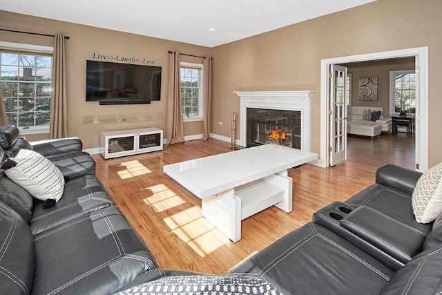 living area with a high end fireplace, light wood-style flooring, baseboards, and recessed lighting