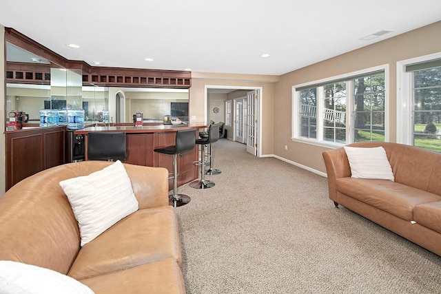 living room featuring recessed lighting, visible vents, baseboards, and light colored carpet