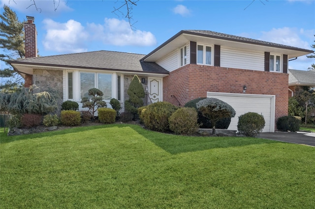 tri-level home with a garage, a chimney, a front lawn, and aphalt driveway