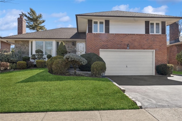 split level home featuring driveway, an attached garage, a front yard, and brick siding