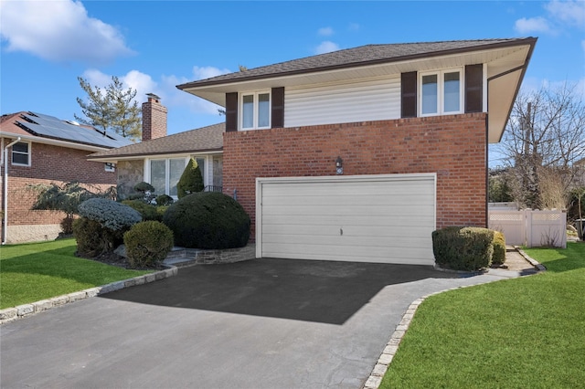 view of front of house featuring driveway, an attached garage, fence, and a front lawn