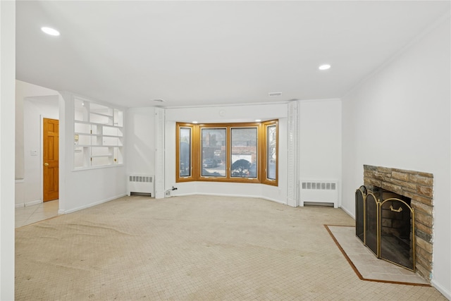 unfurnished living room featuring recessed lighting, carpet, radiator heating unit, and a stone fireplace