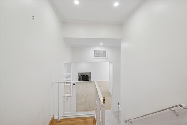 stairs with visible vents, baseboards, ornamental molding, a brick fireplace, and recessed lighting