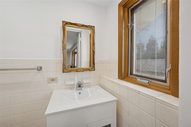 bathroom featuring wainscoting, tile walls, and vanity