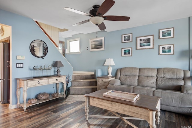 living area featuring ceiling fan, stairway, and wood finished floors