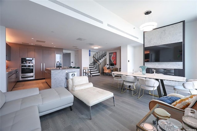 living area featuring stairs, light wood-style flooring, and recessed lighting