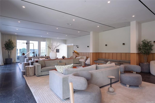 living room with a wainscoted wall, wooden walls, and recessed lighting