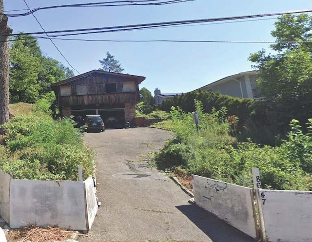 view of front of property with driveway, a garage, and fence