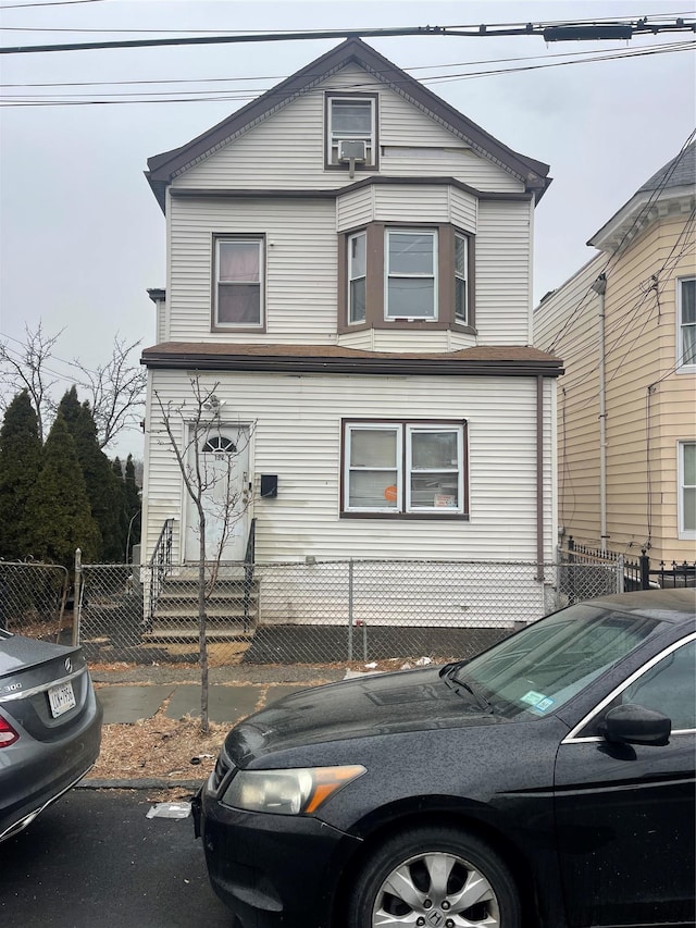 view of front of property with entry steps, a fenced front yard, and a gate