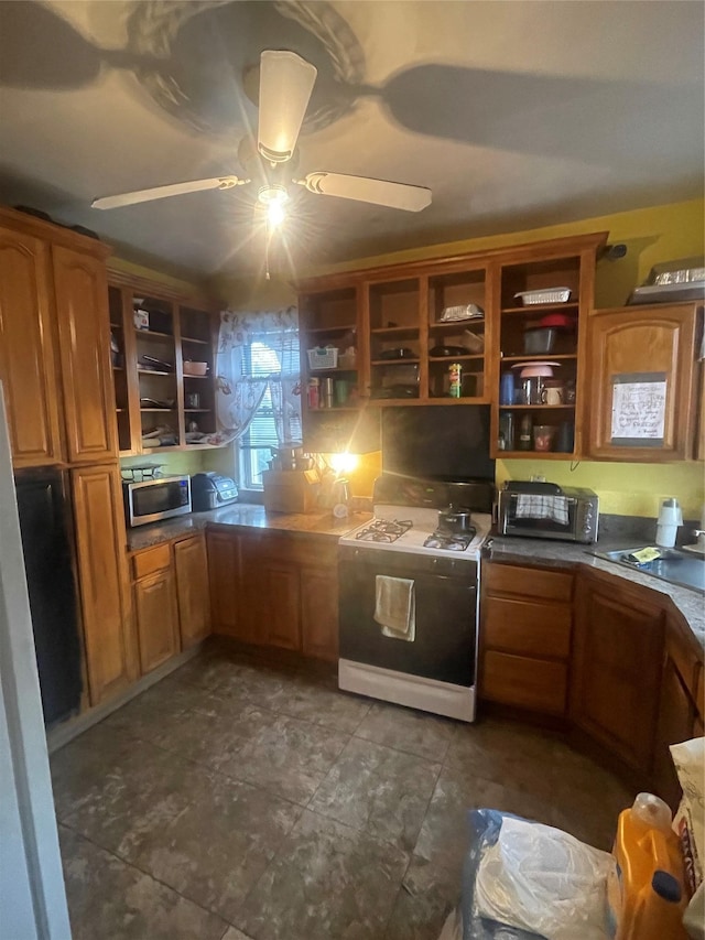 kitchen featuring stainless steel microwave, open shelves, gas range oven, and a ceiling fan