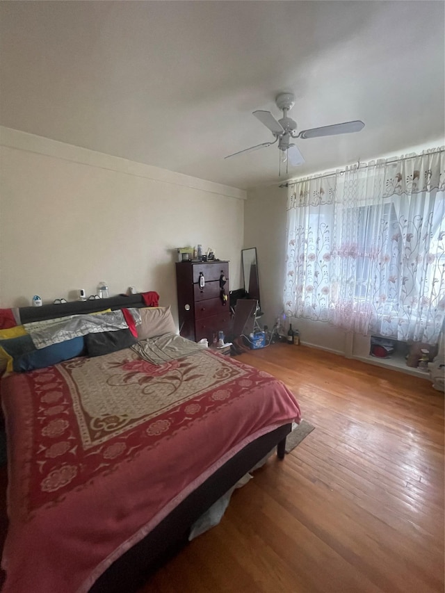 bedroom with a ceiling fan and wood finished floors