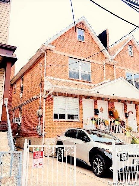 view of front of house featuring brick siding and fence